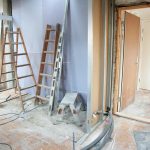 Construction site featuring ladders and tools in a home renovation setting.