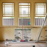 An empty room featuring large windows, ready for renovation in Sydney, Australia.